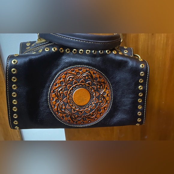 Black leather cross body purse with orange colored medallion on front. - Picture 9 of 14